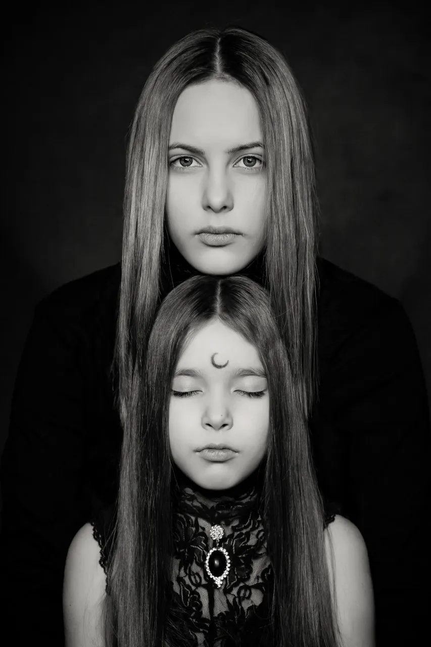Daughter with her eyes closed and mom resting her chin on daughter's head