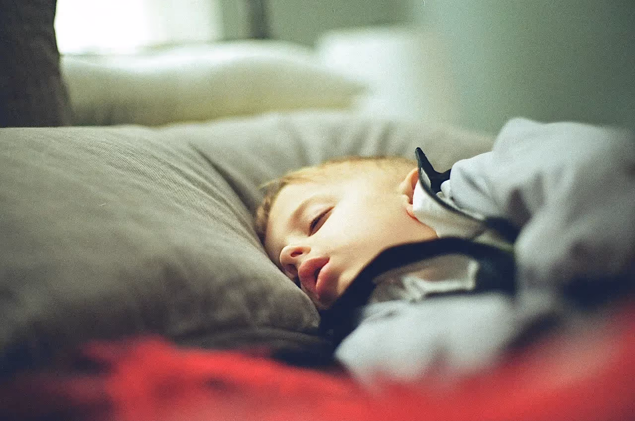 A child sleeping after a busy day of playing sports.