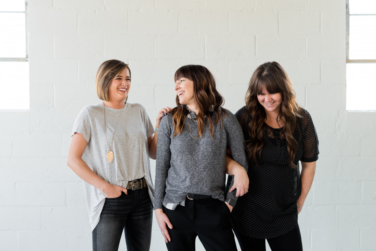 A group of women standing together smiling and laughing