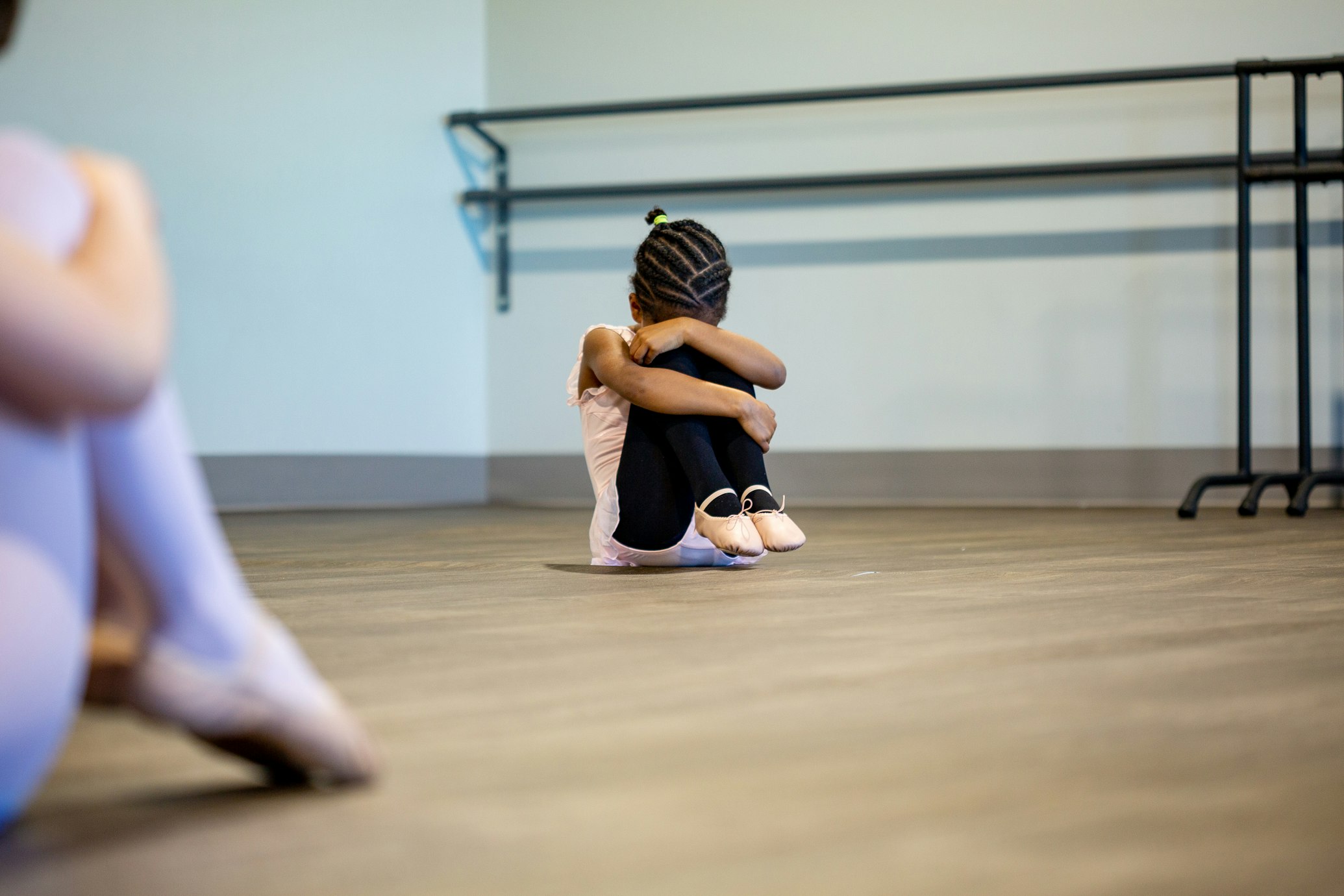 Little girl holding her head down on her knees