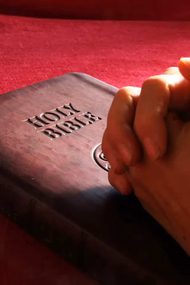 praying hands on Bible