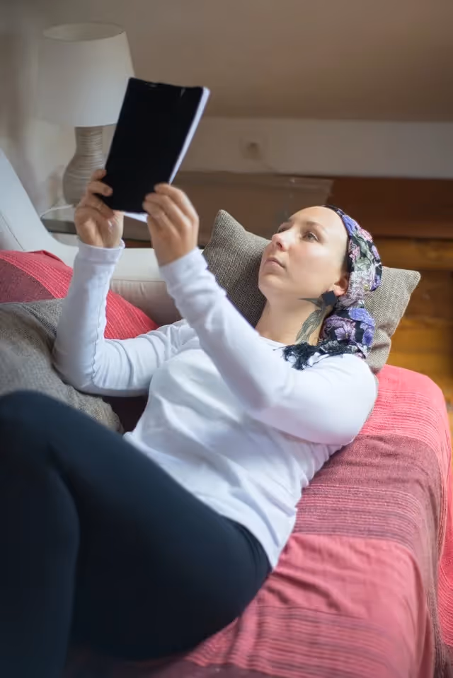 Woman lying on couch reading