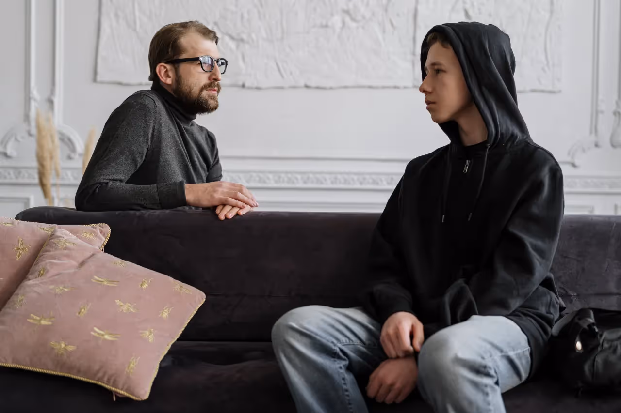 Teen sitting on a couch speaking with a therapist