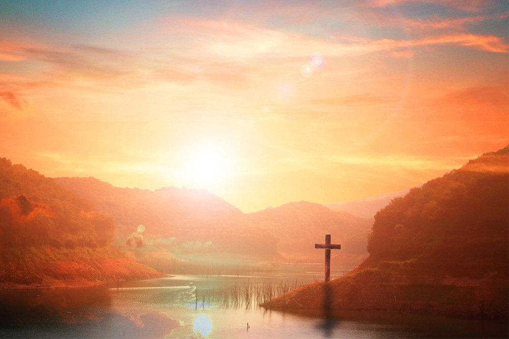View of the water with a cross on land.