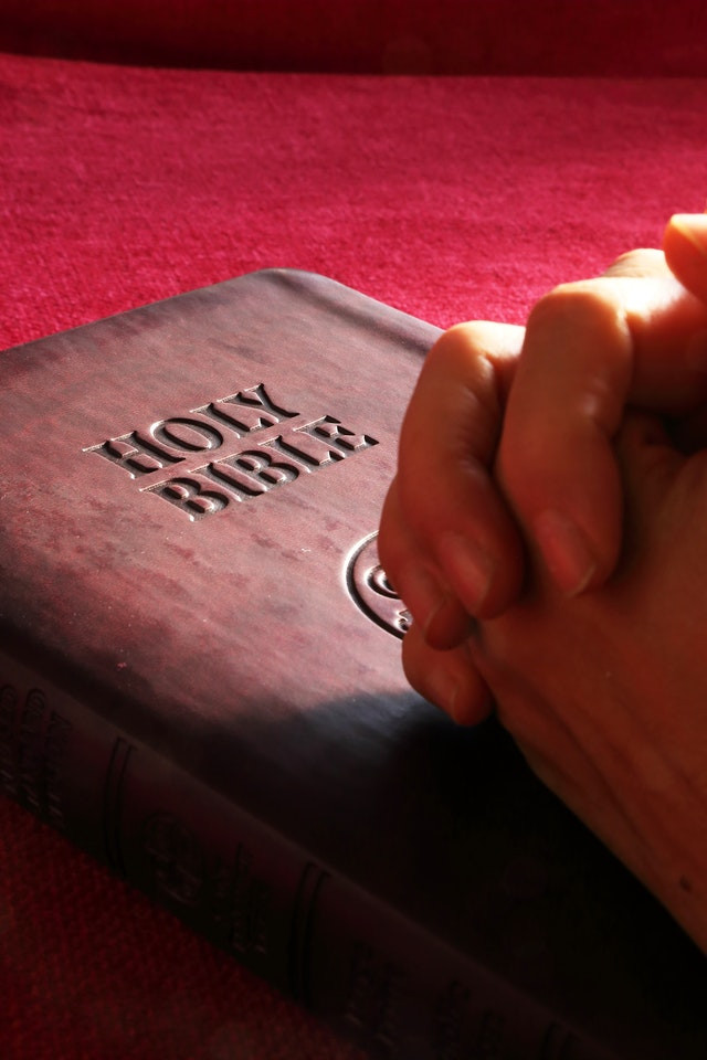 Person praying over a bible