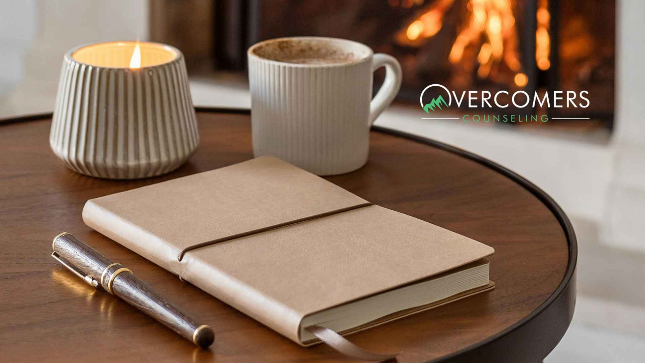 Journal laying on the table next to cup and candle.