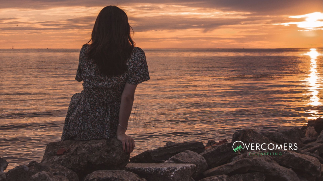 a person staring out at water from a coast line