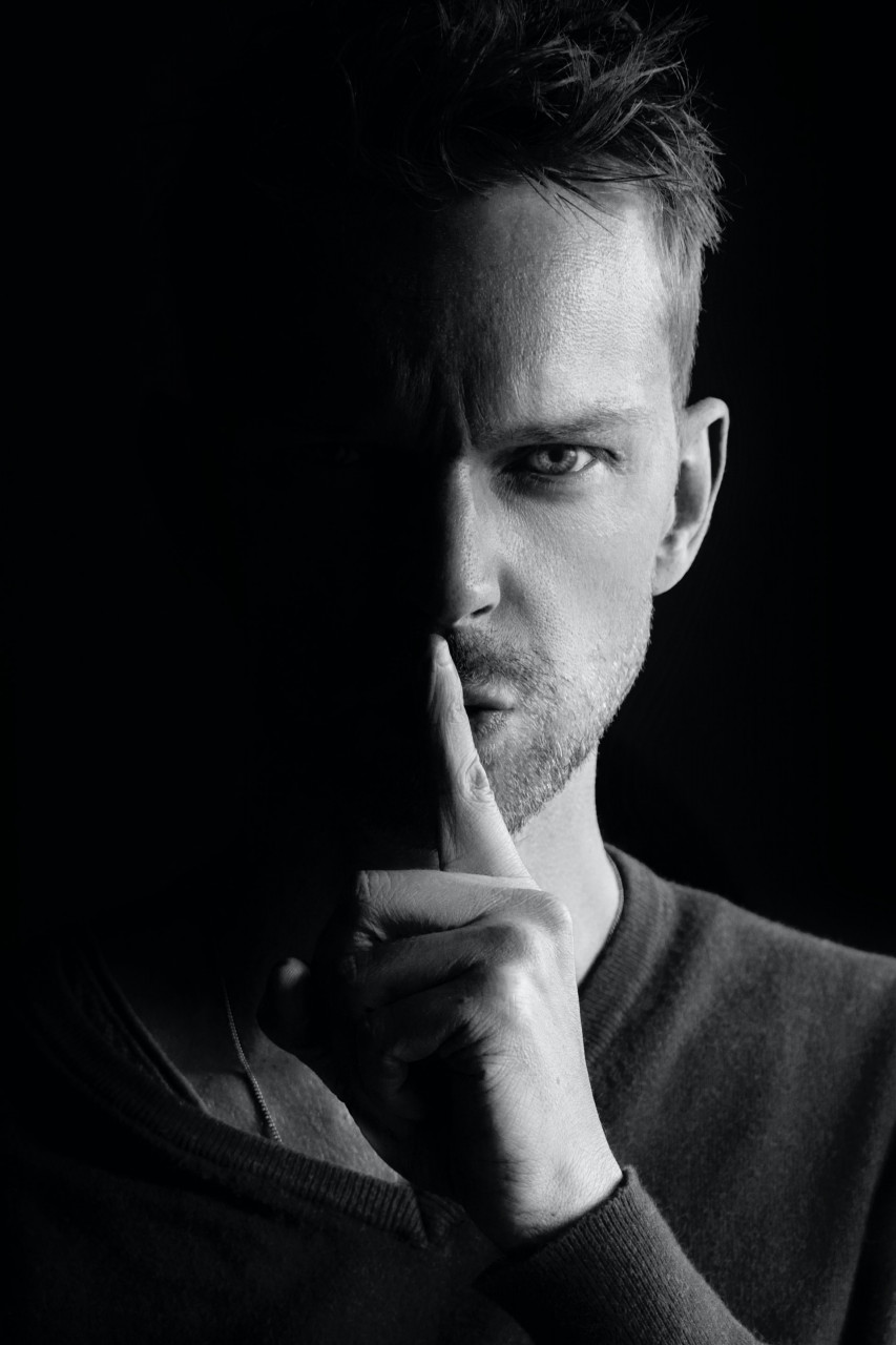 Man holding his finger over his lips in a shhh manner