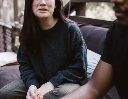 Woman crying sitting next to a man outside