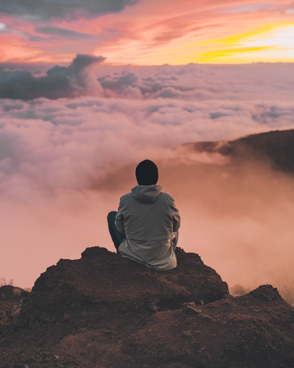 A man meditating on a rock.
