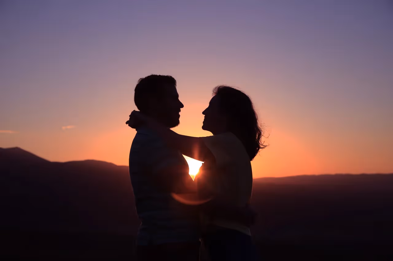 A couple embracing in the sunset.