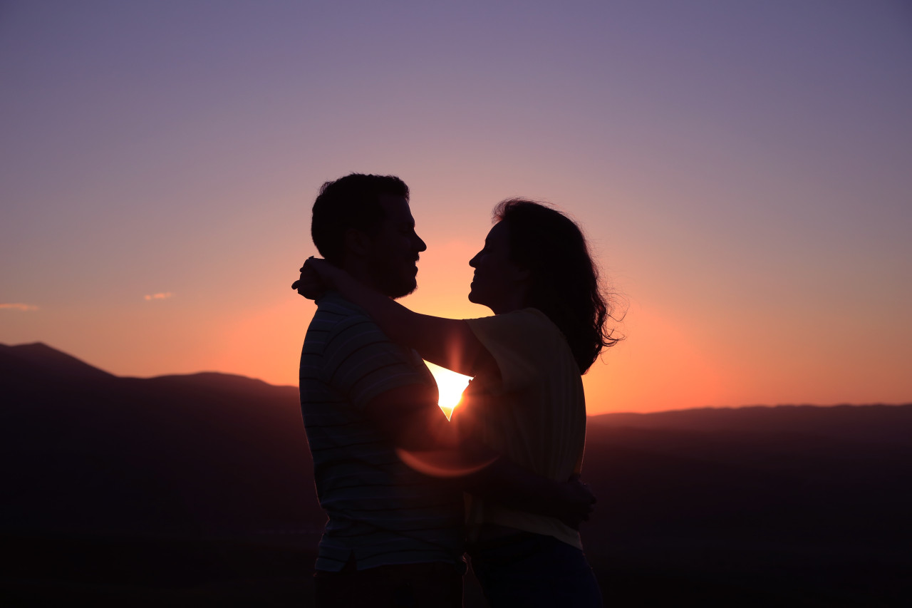 A couple embracing in the sunset.