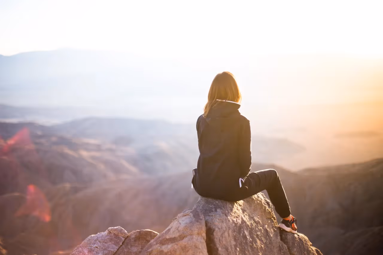 A lady doing some self-reflection on a rock.