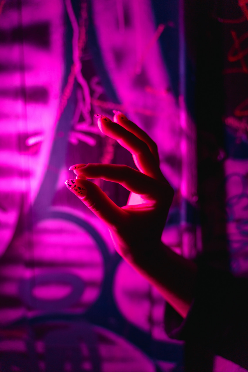 A person holding up a pill.