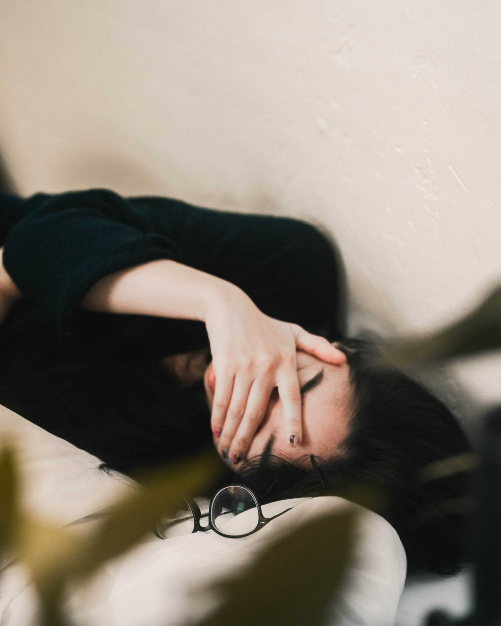 a woman lying down with her hand over her face