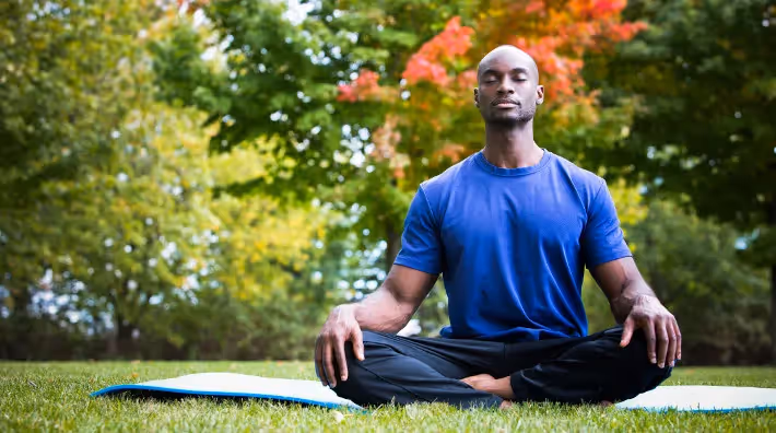 A man meditating outside.