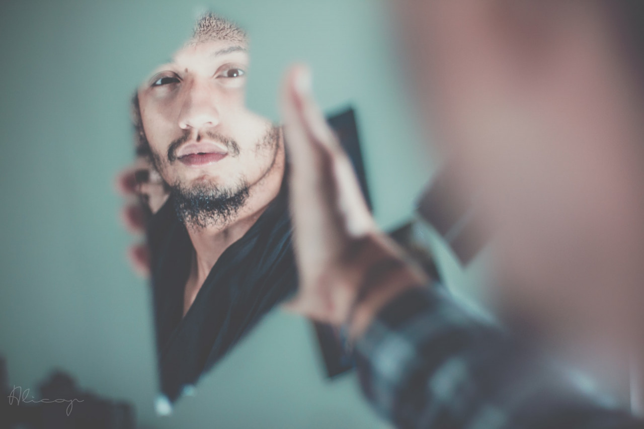 A person holding up a mirror looking at their reflection