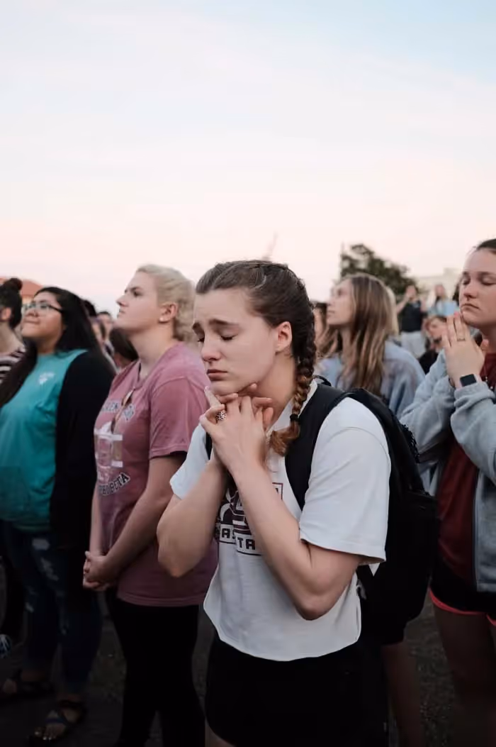 a young woman praying with her eyes closed