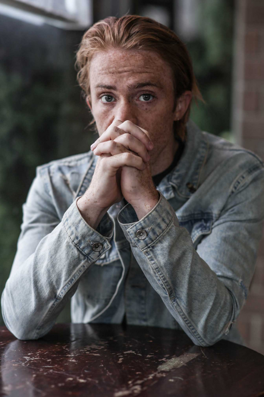 a scared person clasping their hands together
