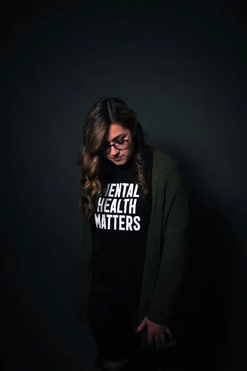 a person looking down while wearing a shirt that says mental health matters