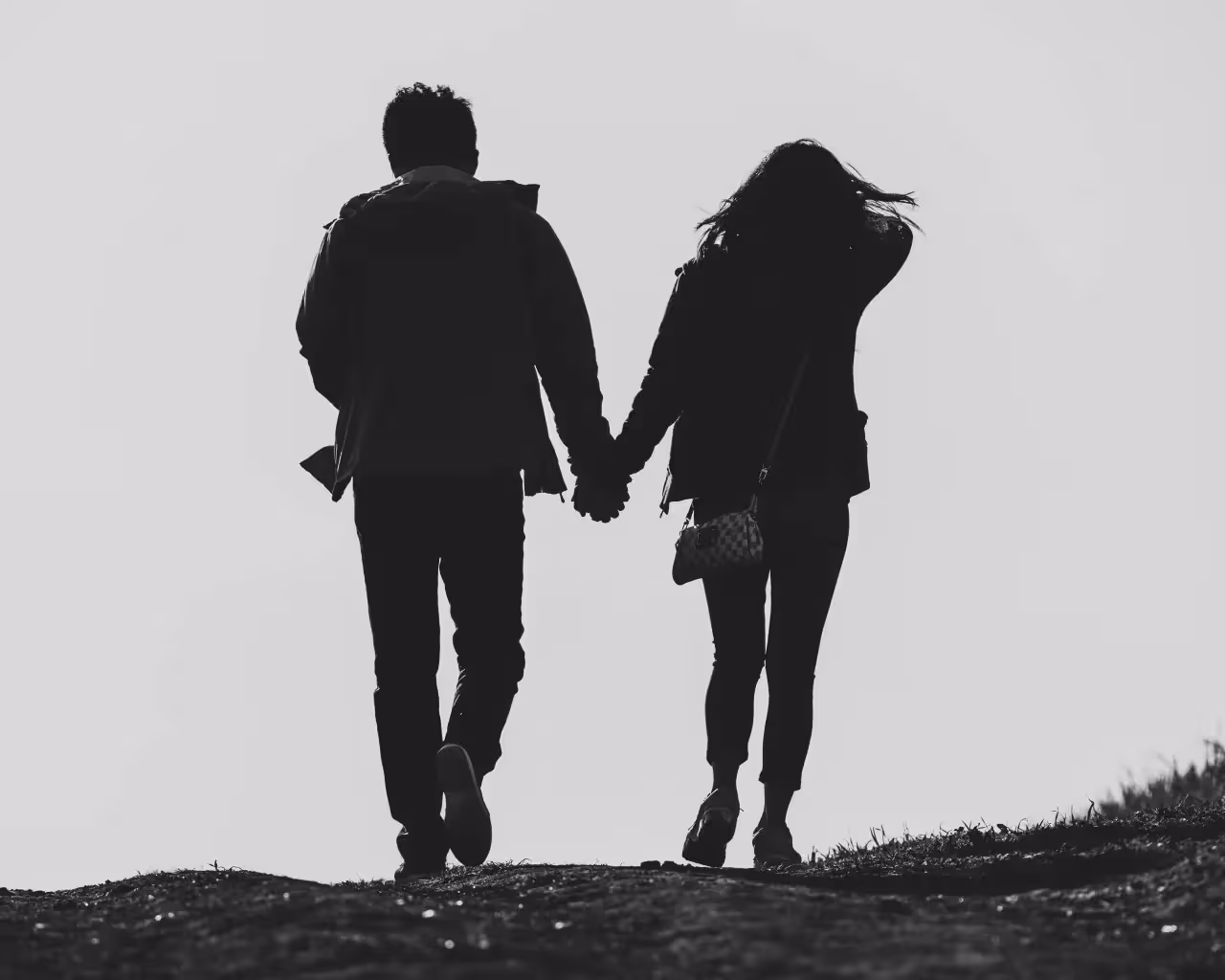 a couple walking together while holding hands