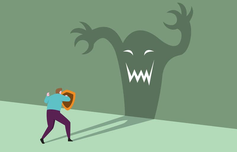 Cartoon of a person holding a shield and the shadow being a monster