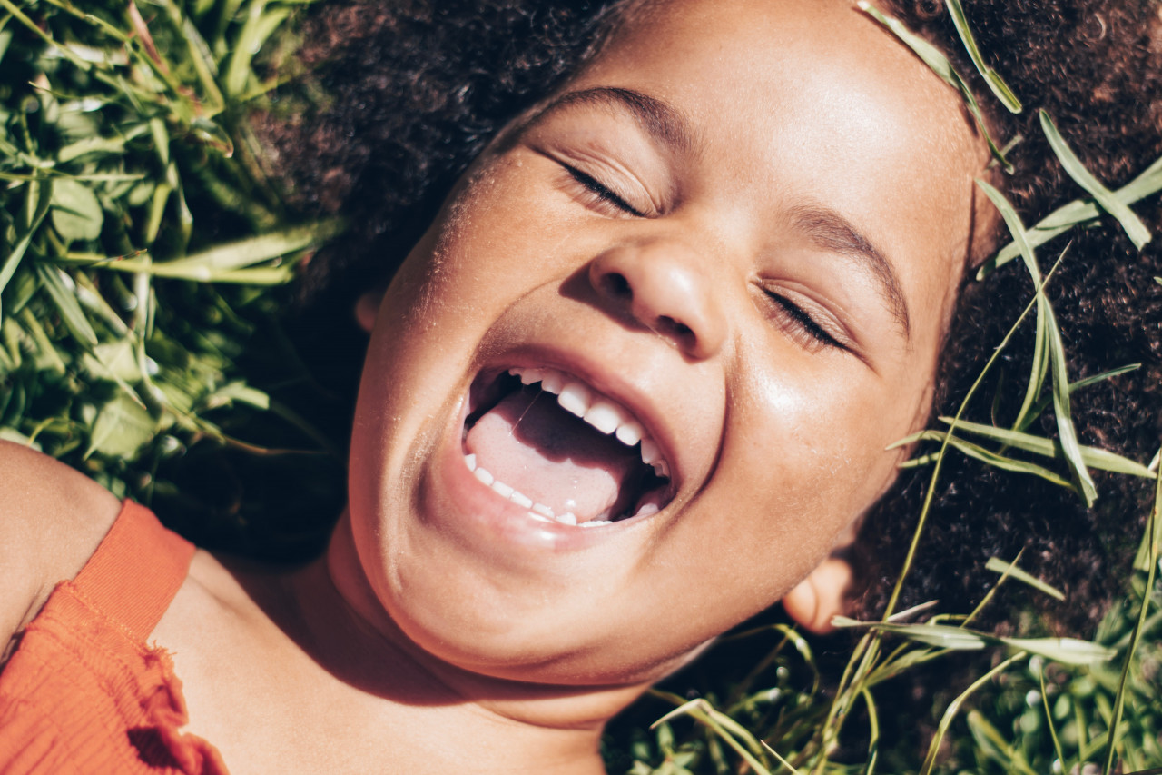 Girl laying in the grass laughing
