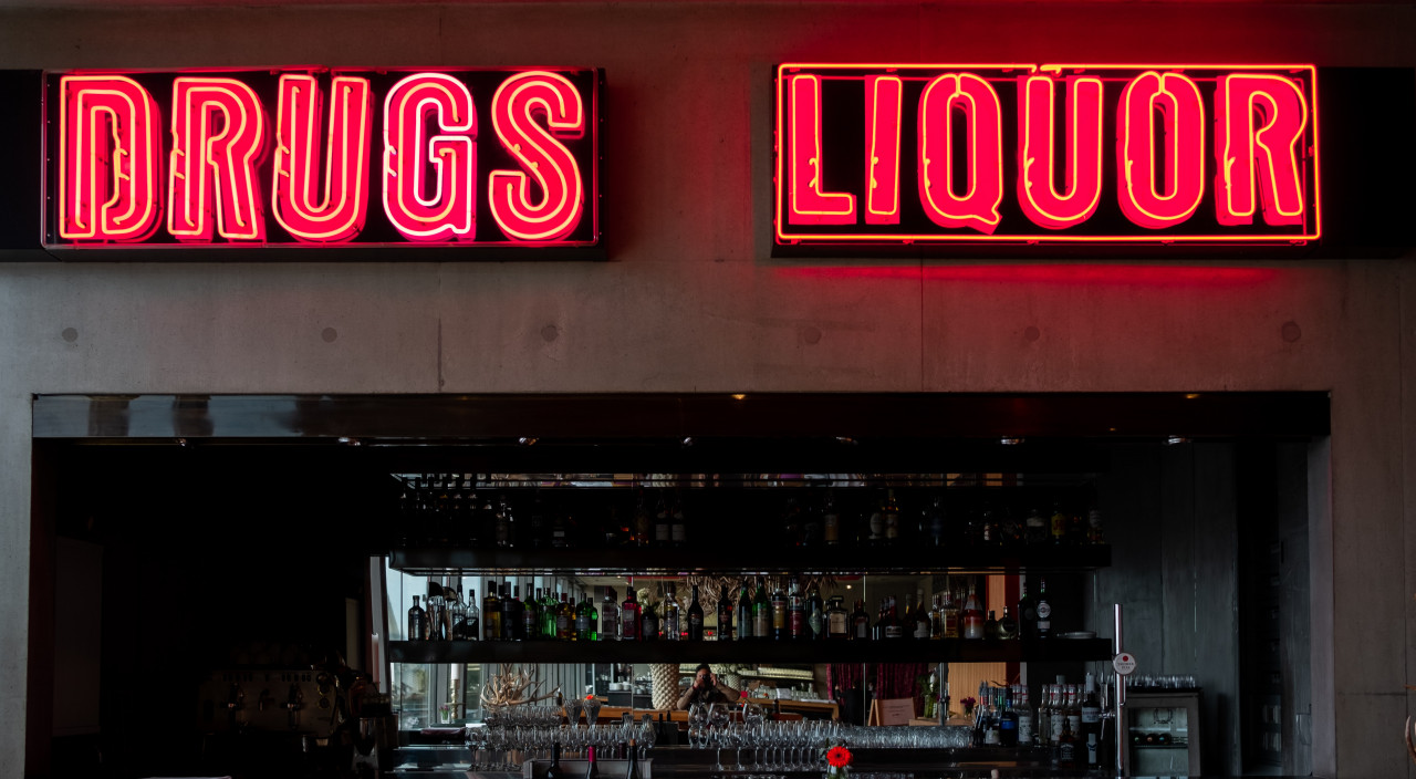 Neon signs that say Drugs and Liquor