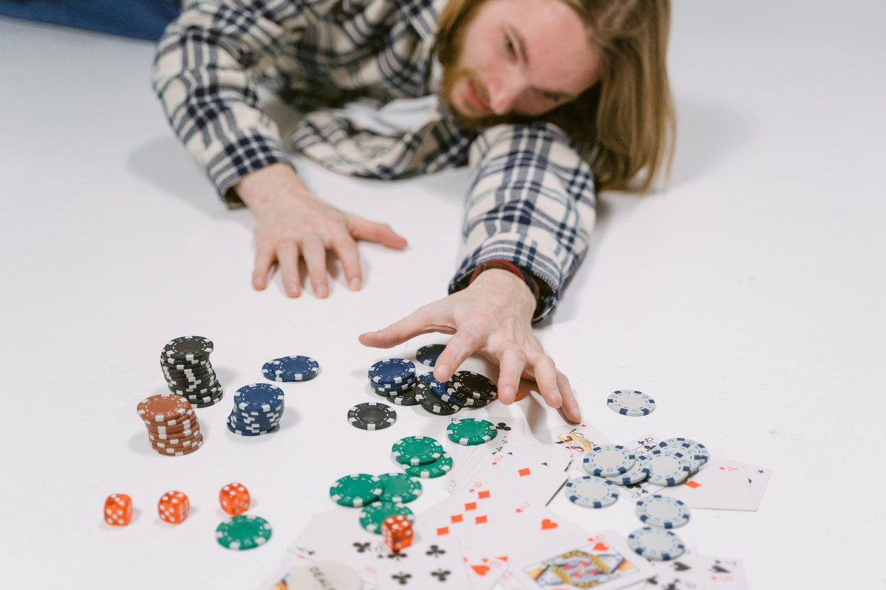 A man reaching for poker chips and cards