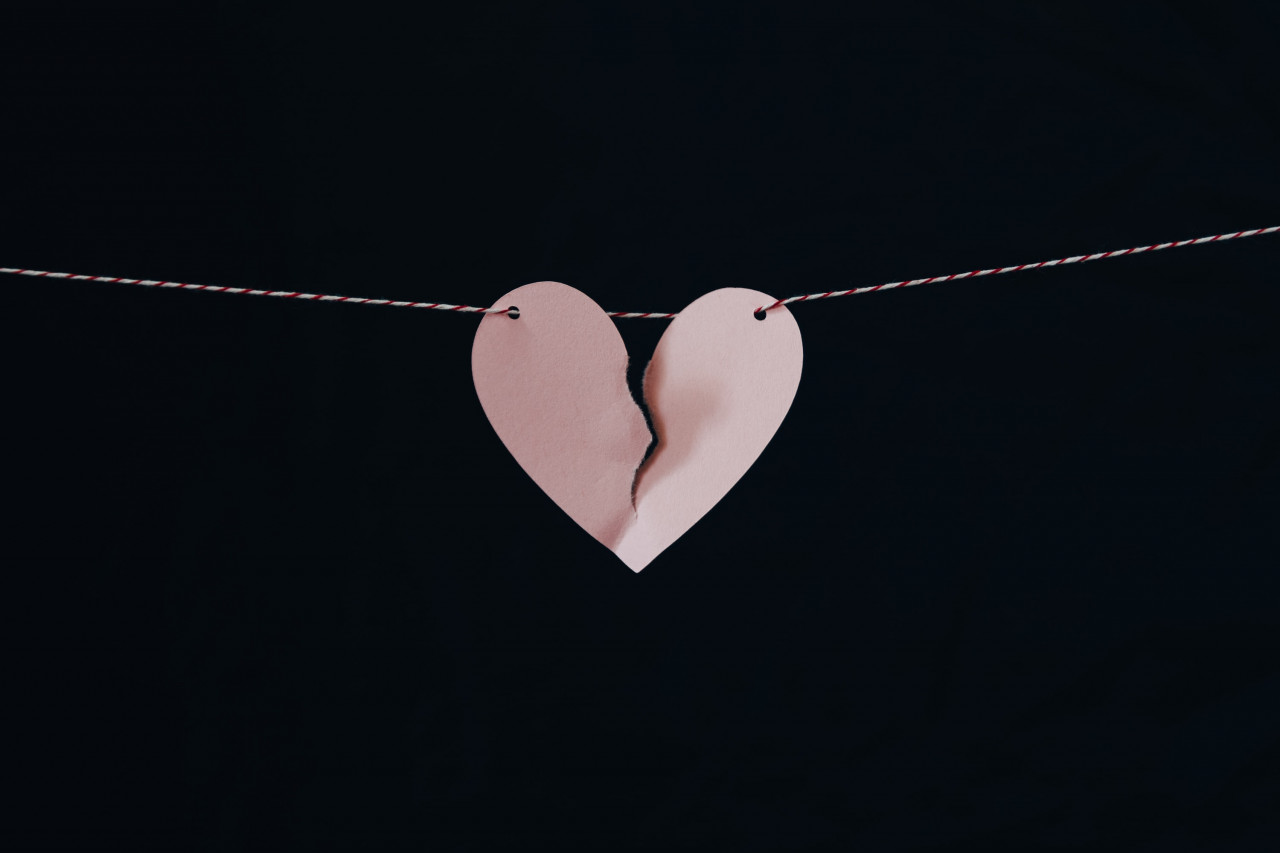 a paper broken heart hanging on a string