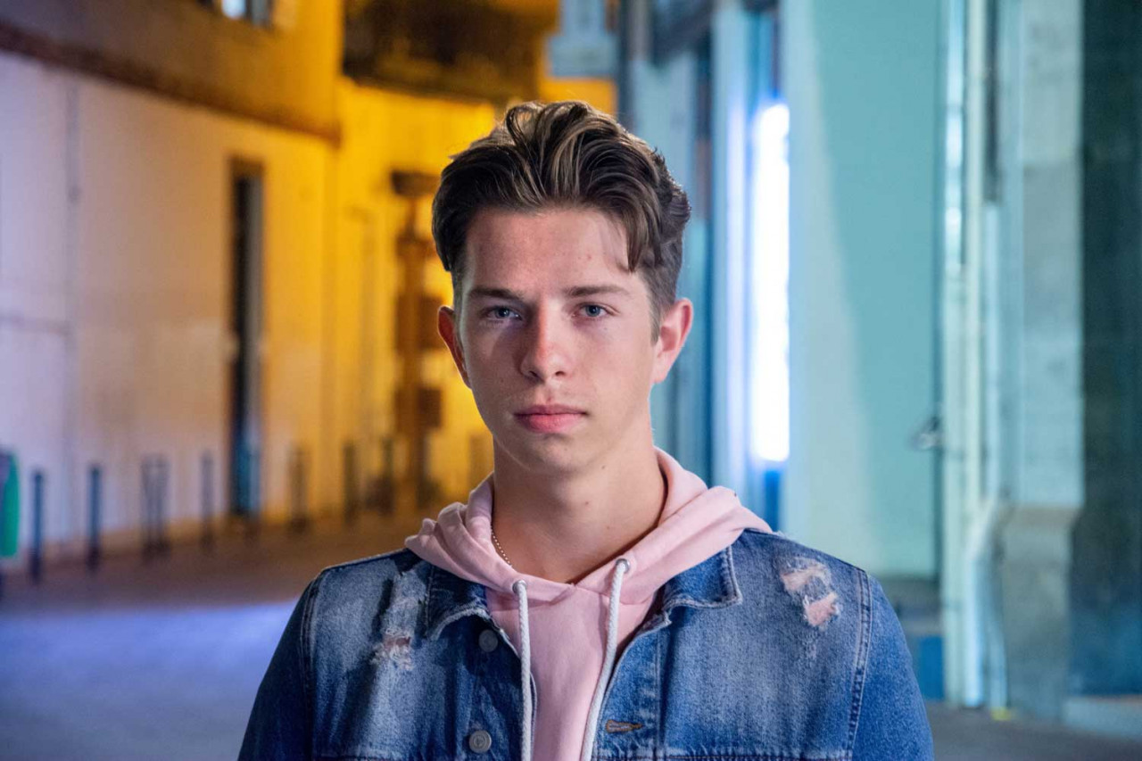 a younger teenager with a solemn look on their face