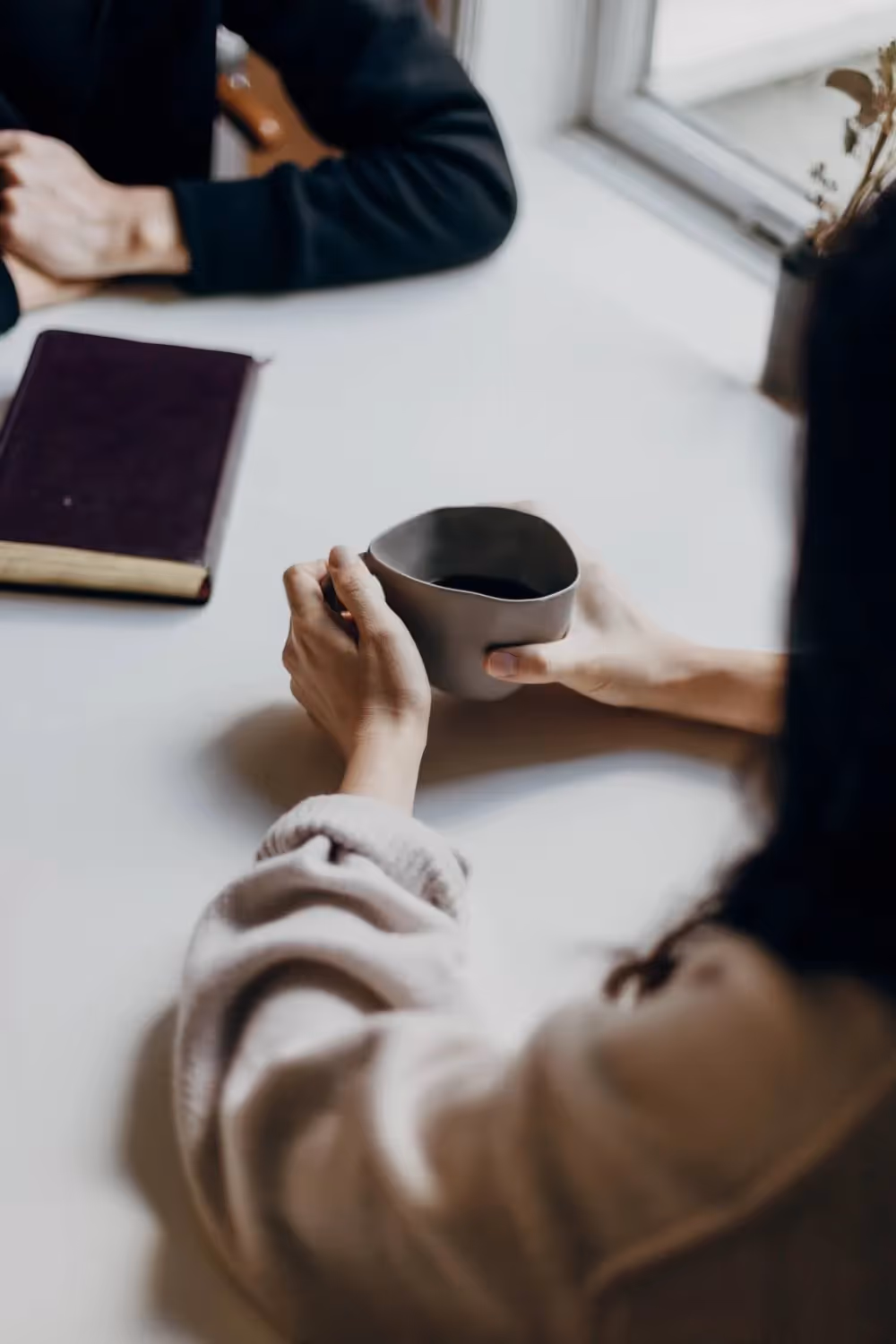 women sitting at a table with a cup of coffee
