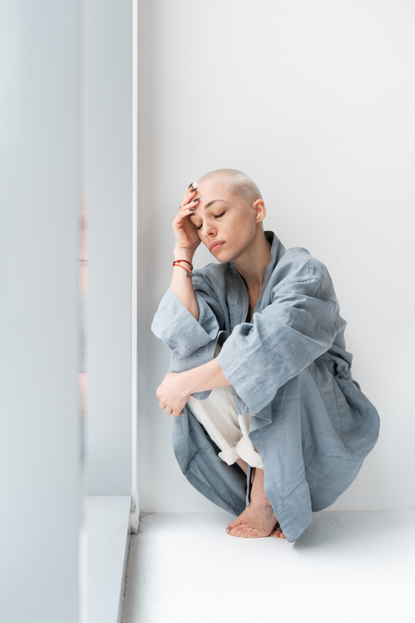A cancer patient crouching in the room
