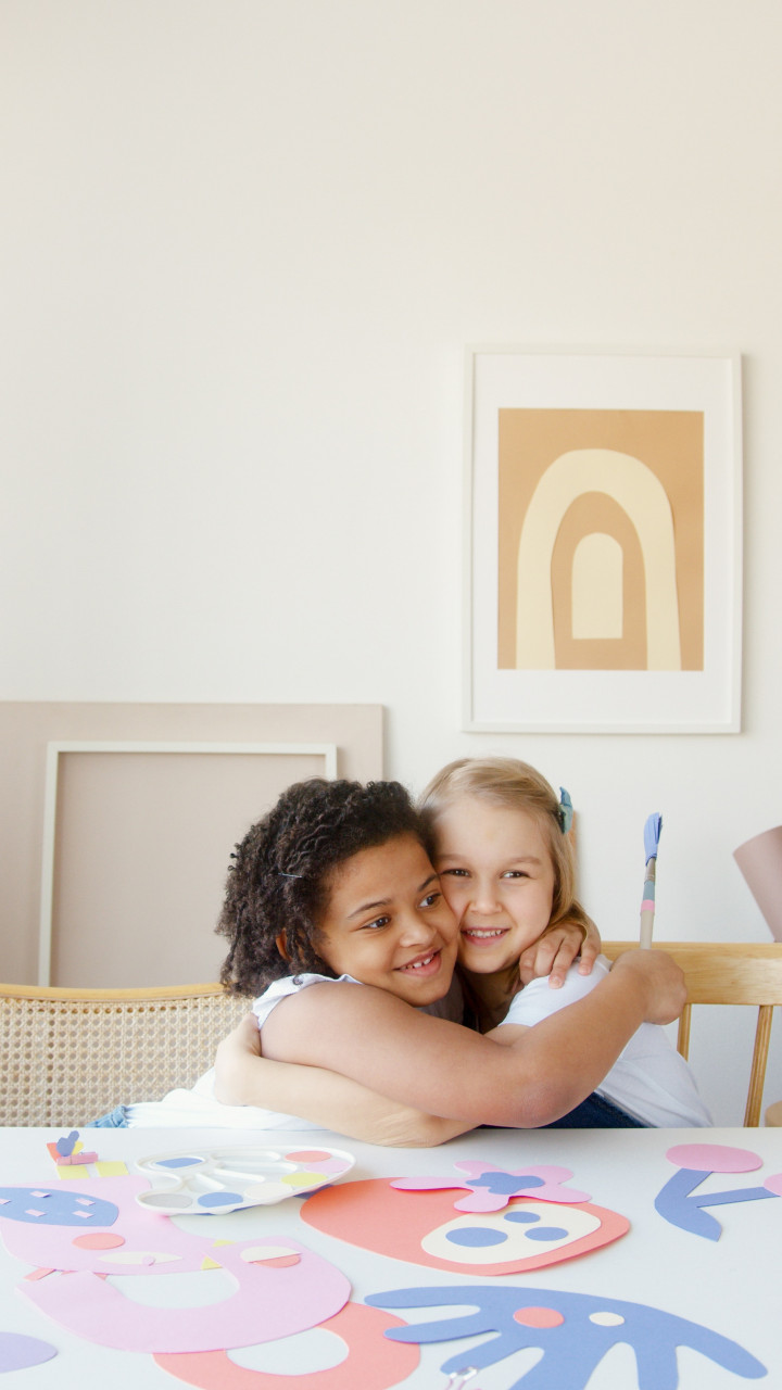 Two girls hugging each other.