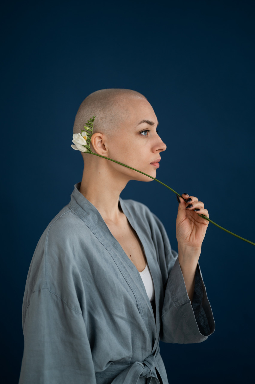 A cancer patient holding a flower.