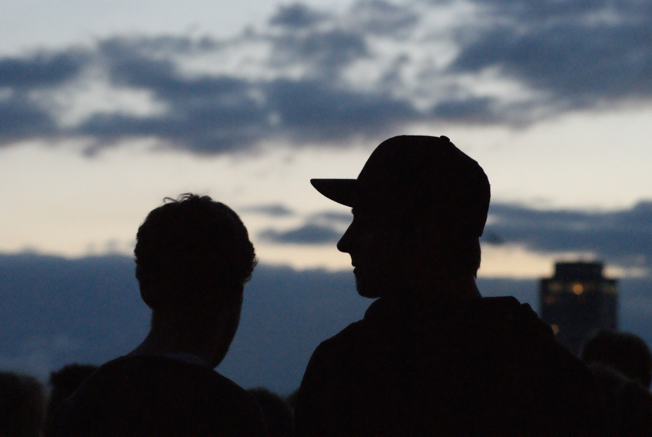 two teenagers standing next to eachother at night