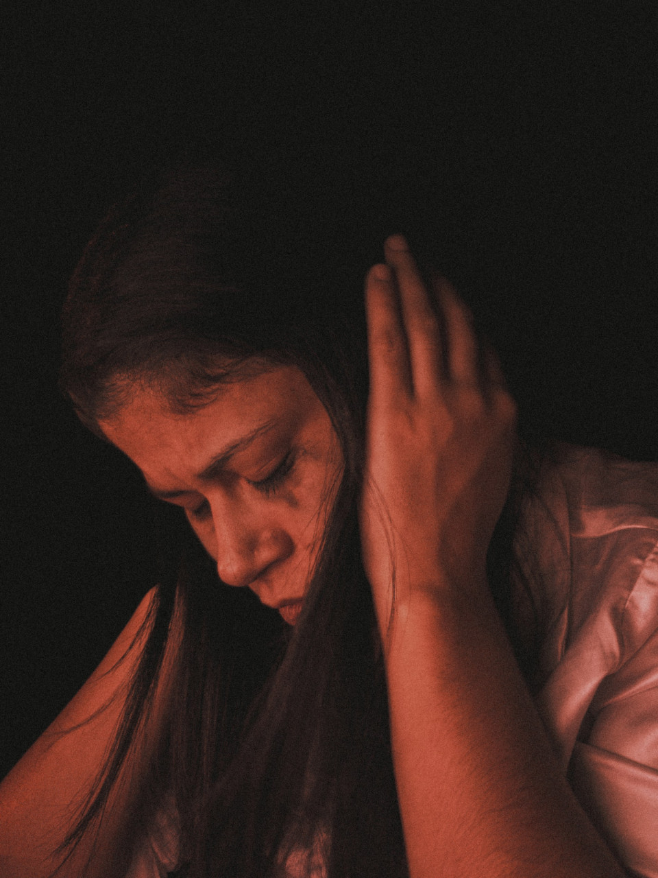 A sad woman blocking out her ears.