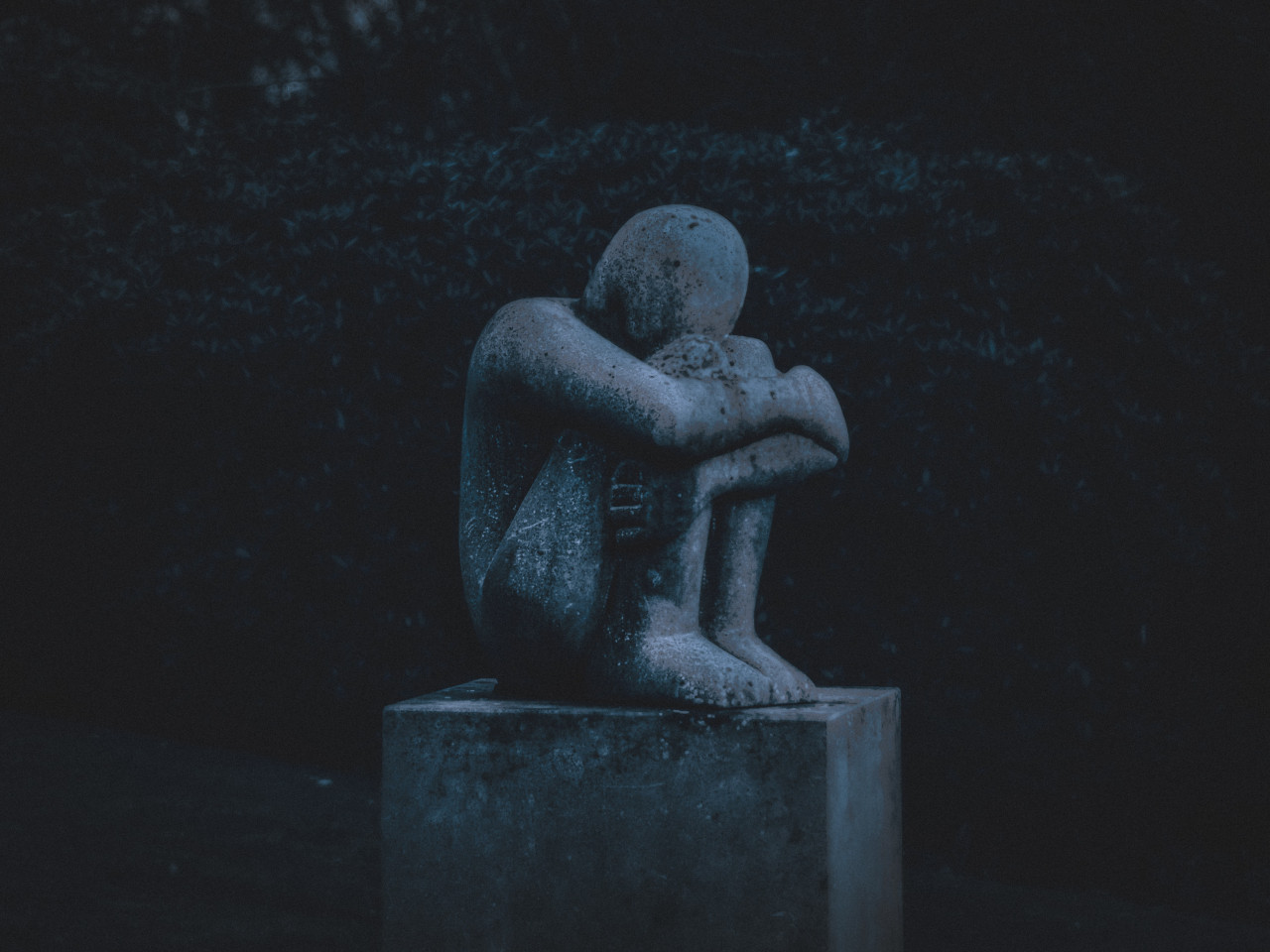 A statue in a grieving pose.