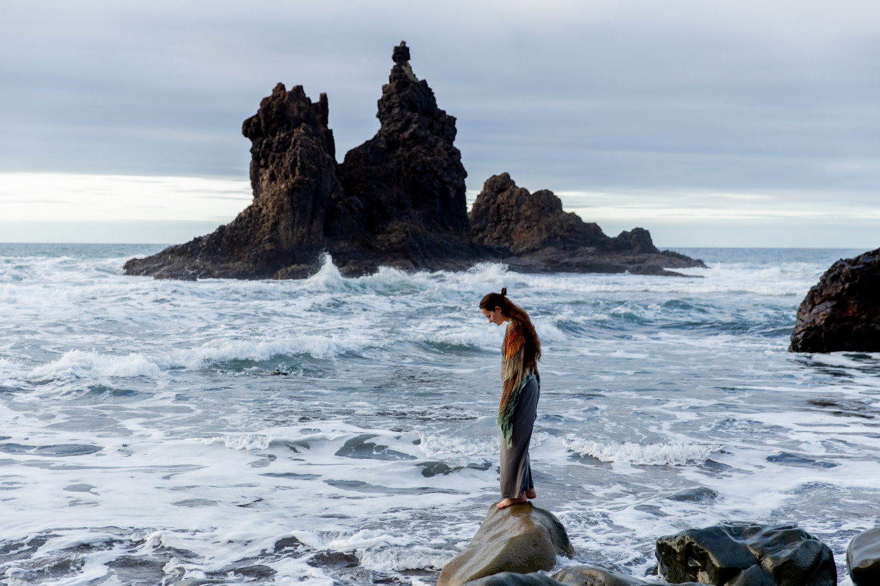 A grieving man standing by the water.