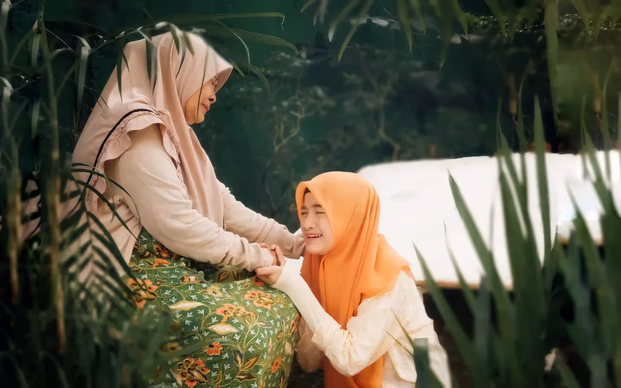 An adult female consoling a young girl.