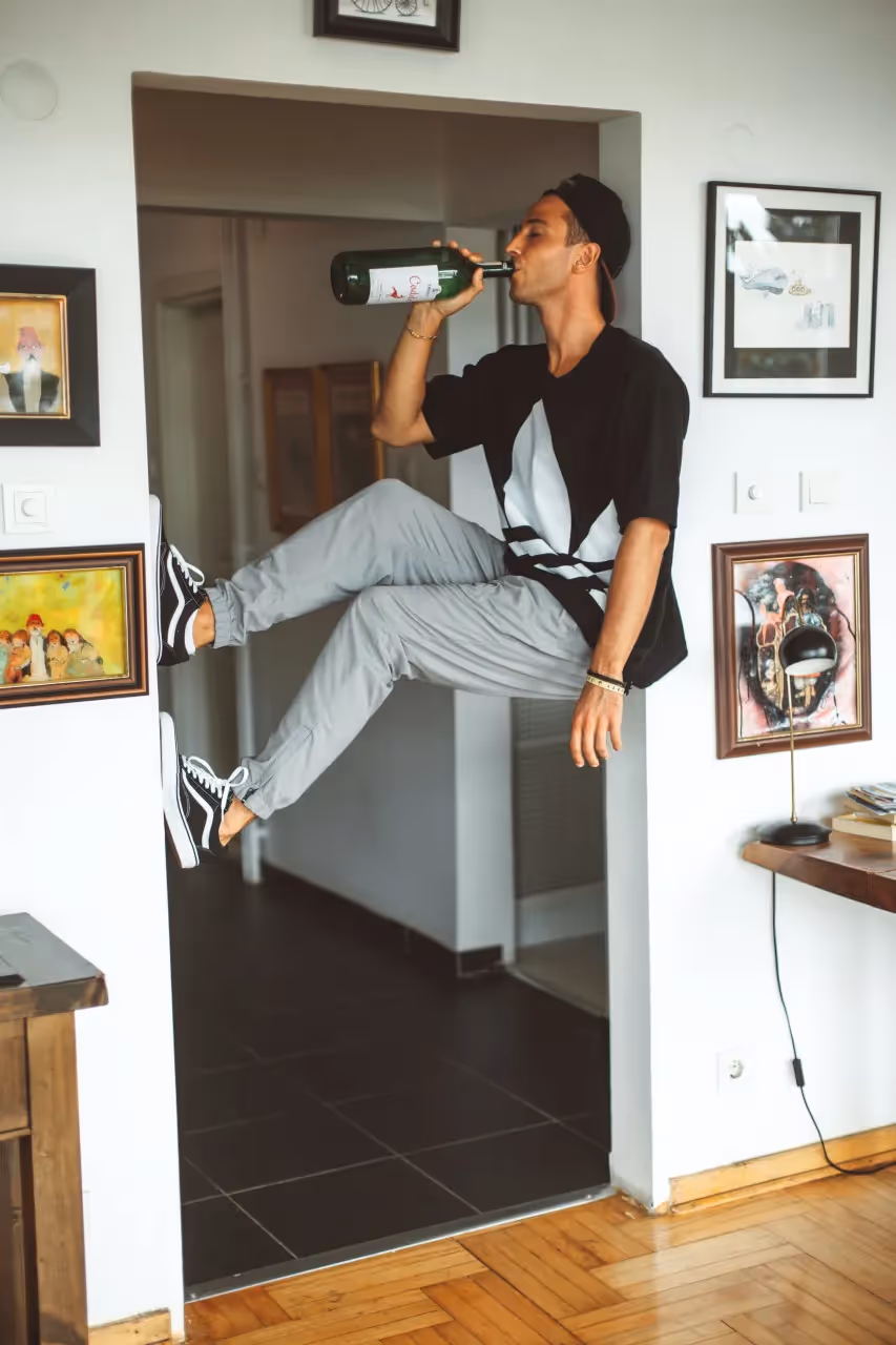 A man drinking a whole bottle of alcohol.