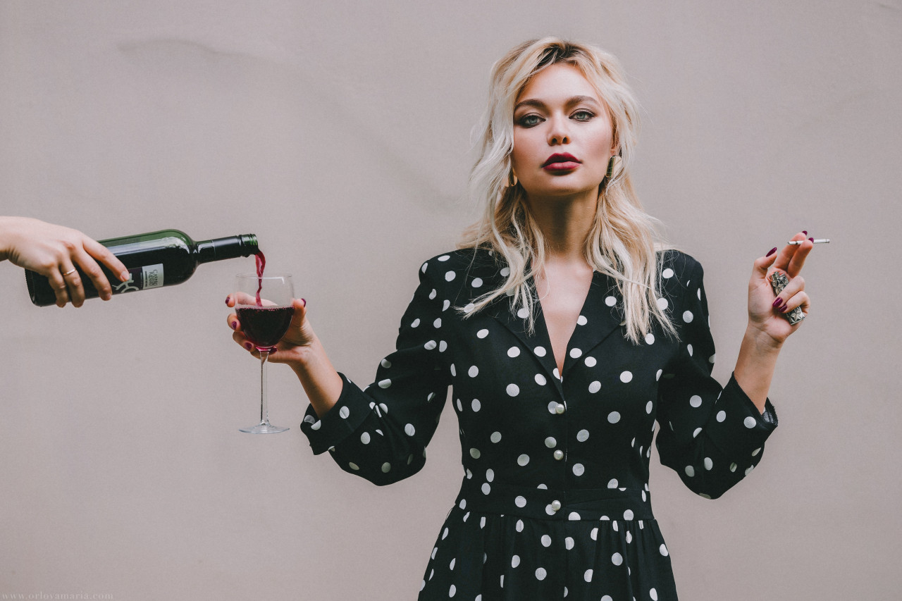 A woman being poured alcohol.