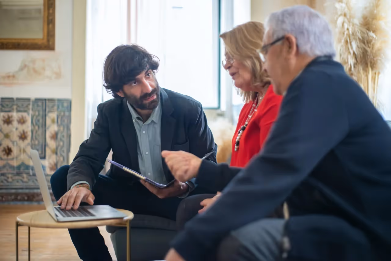 A man talking to an older couple.