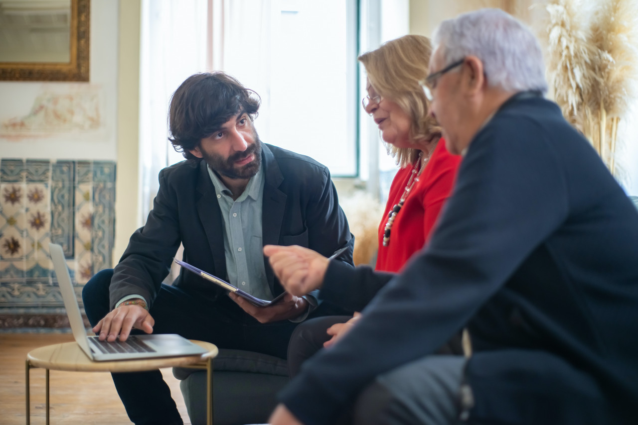 A man talking to an older couple.