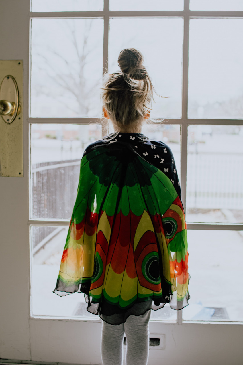 A young girl looking outside the window.