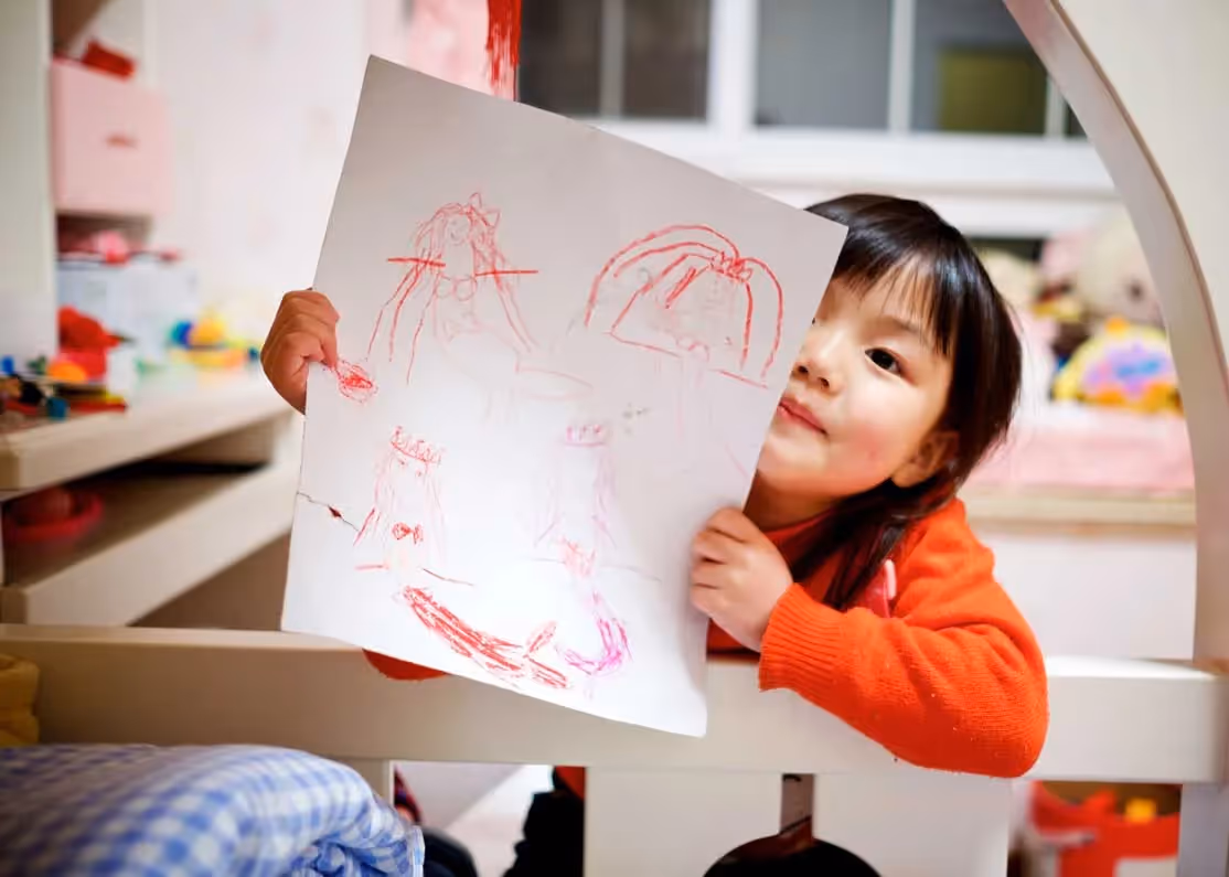 child holding up drawing