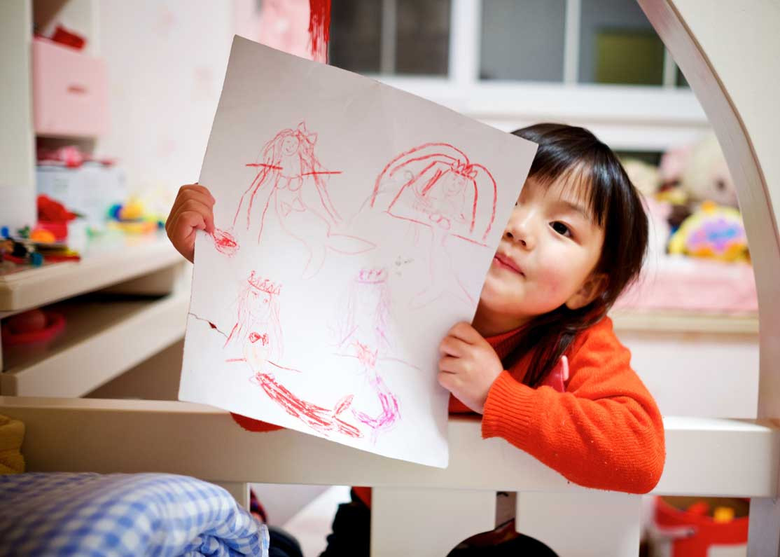 child holding up drawing