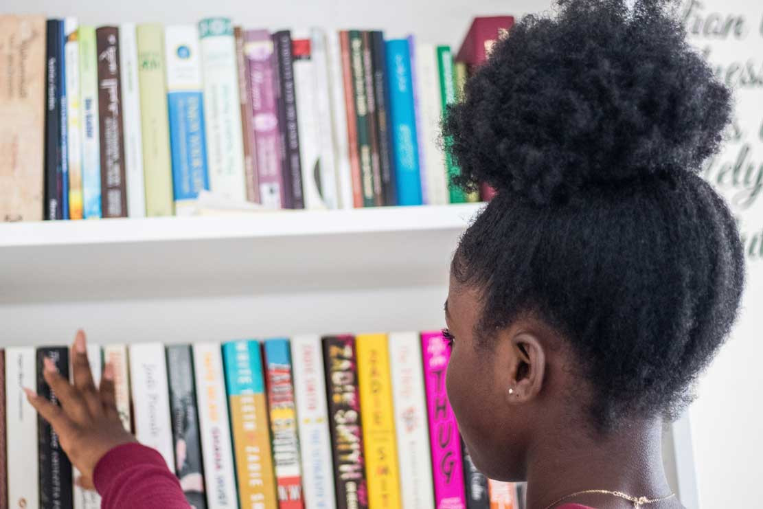 a child touching books on a shelf