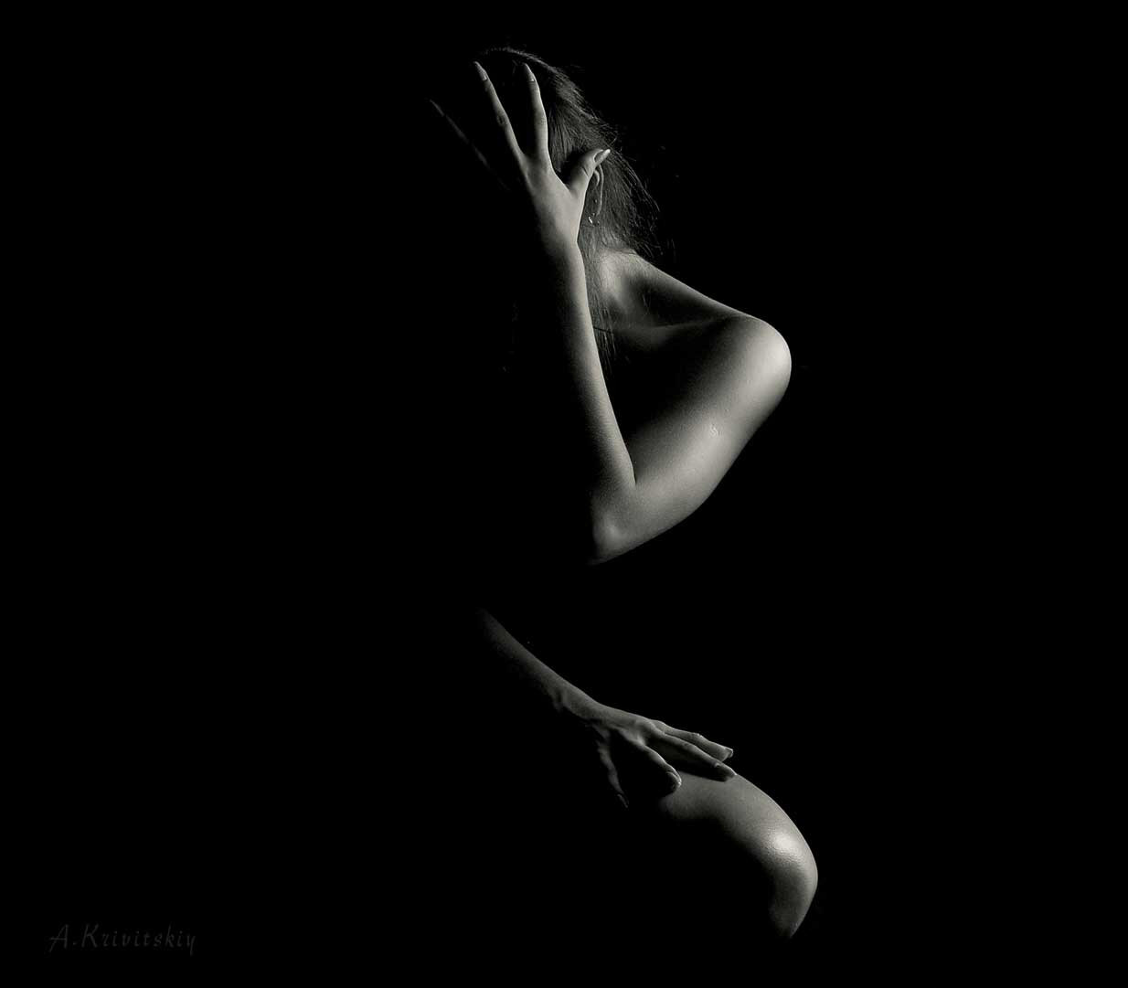 a young person hugging themselves in the dark