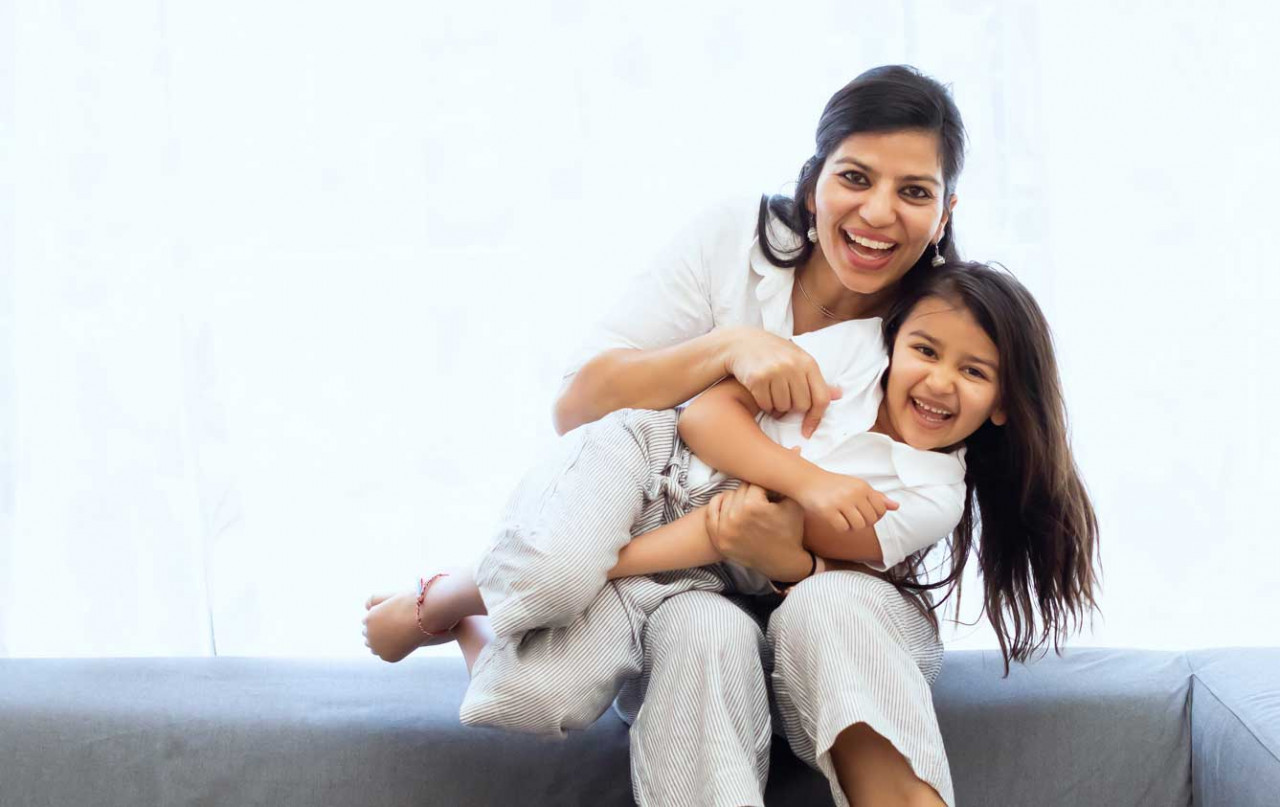a woman and her daughter playing a smiling